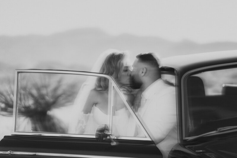 Couple kisses in vintage car during Las Vegas Elopement