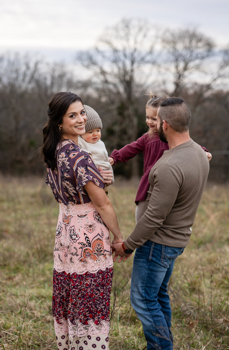 Family of four looking at one another and the camera taken in a field in De Soto, Missouri. 