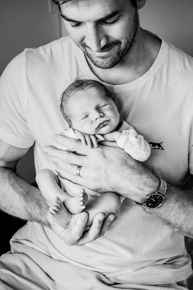 dad holding bbay boy in his hands black and white photo