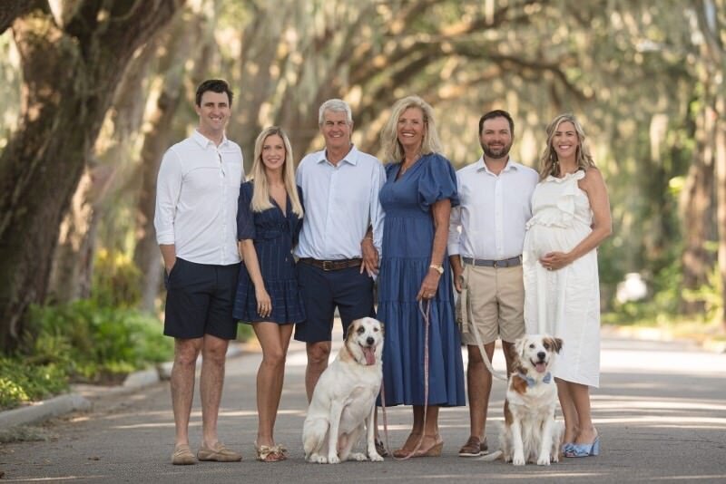 A-family-posing-together-with-their-dogs-on-a-tree-lined-street