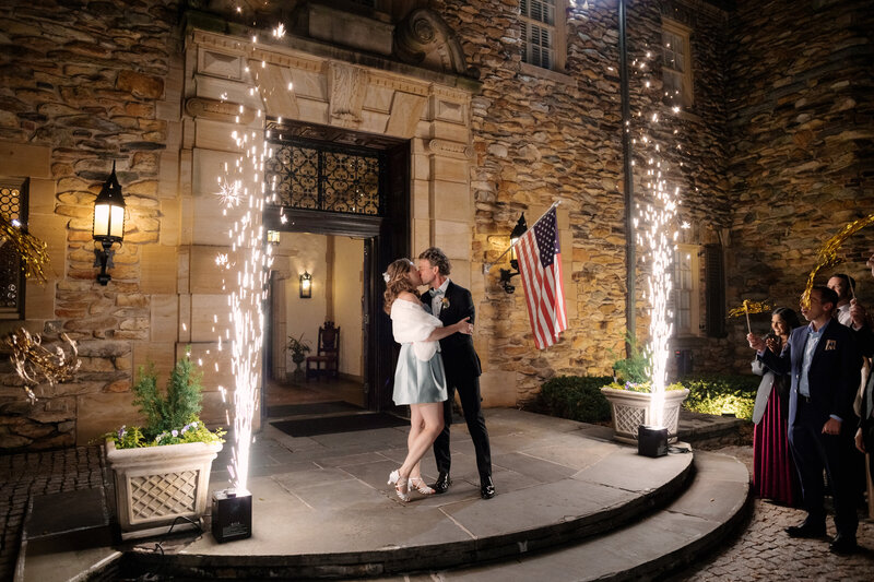 November wedding at Graylyn Estate, designed and planned by Charming Carolina — bride and groom exiting the manor house with cold sparks lighting up the walkway.