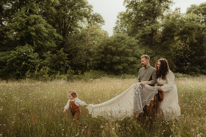 family outside sitting on blanket outdoors nature