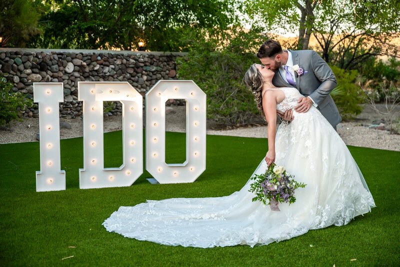 Married Couple Kissing next to I DO Marquee Letters
