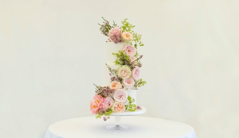 Beautiful pale wedding cake with heavy florals running down the cake