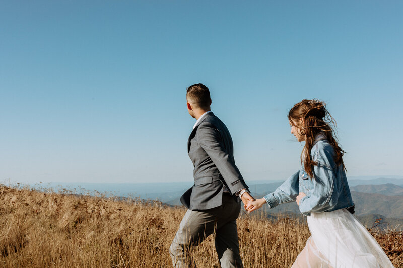 photo of bride and groom walking on a mountain after their adventurous elopement in Asheville