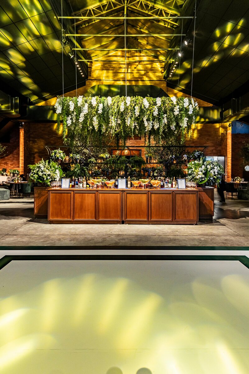 BP Collective luxury indoor event bar with cascading floral ceiling installation, dramatic lighting, and elevated garden-inspired design.
