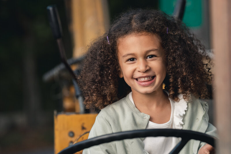 curly hair kid sitting on tractor