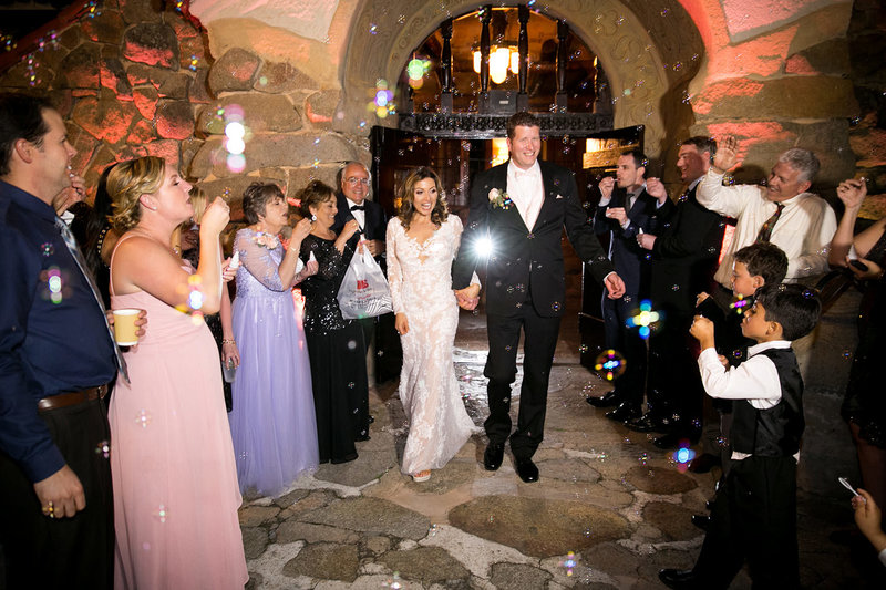 bride and groom walking out of their reception