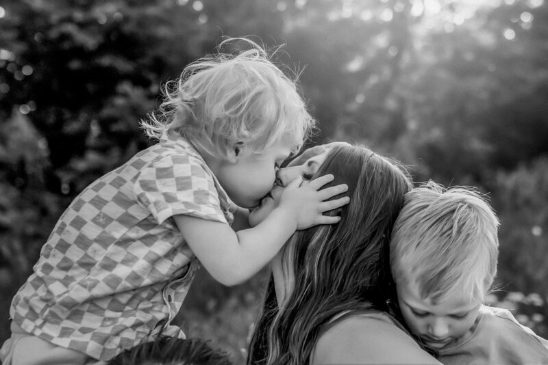 Mom and son give each other a kiss during their family photoshoot in Kansas City