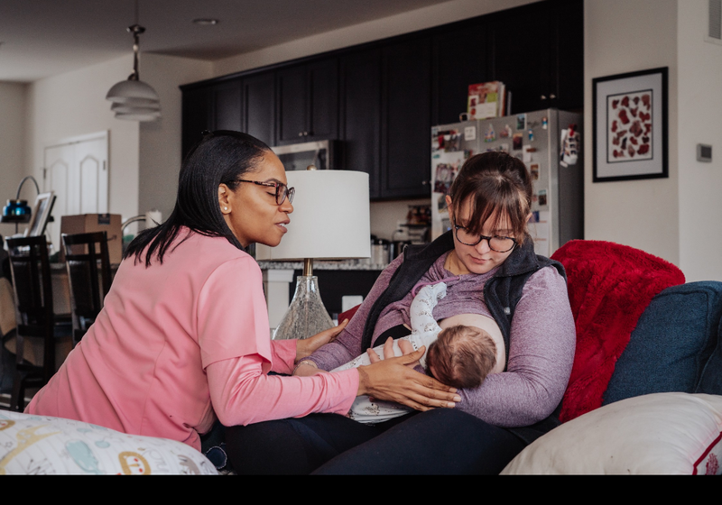 Doula supports a mother during breast feeding to help lactation