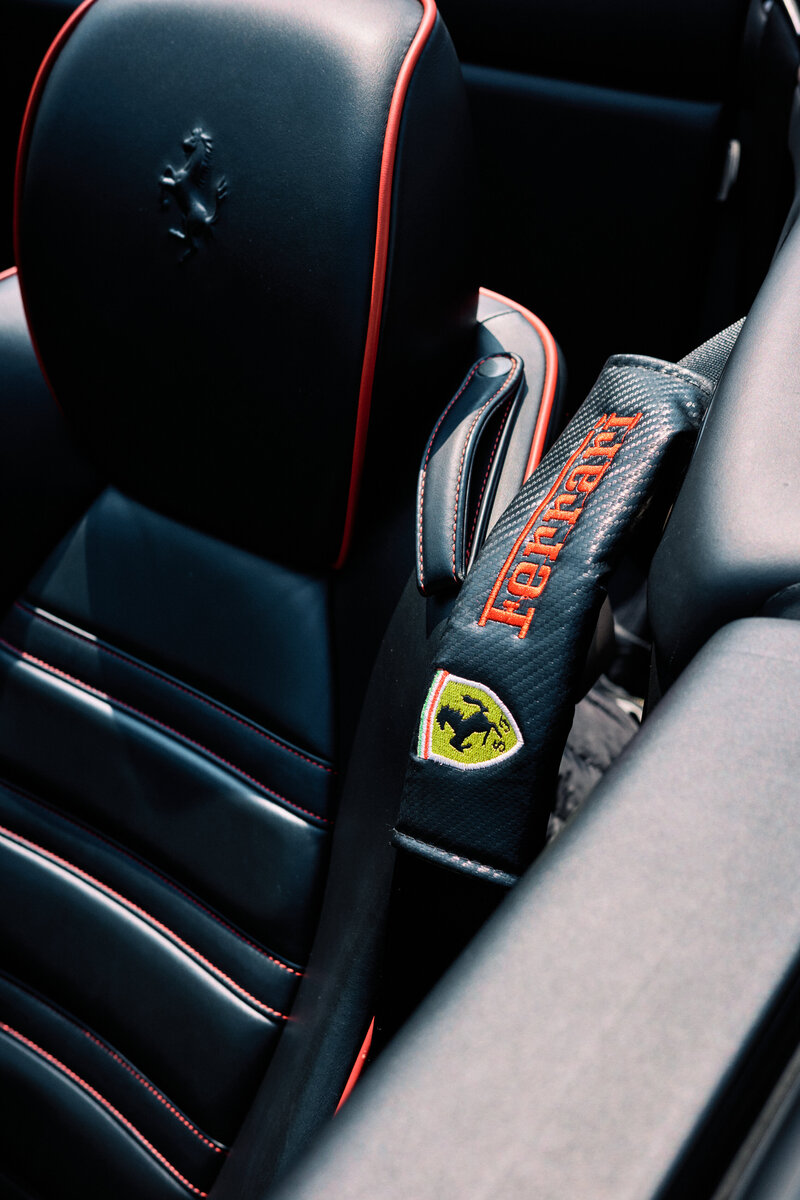 Close-up of the Ferrari California’s black leather interior with red accents and logo, showcasing the luxurious seating details of Tokyo Luxe Drive’s premium tour car.