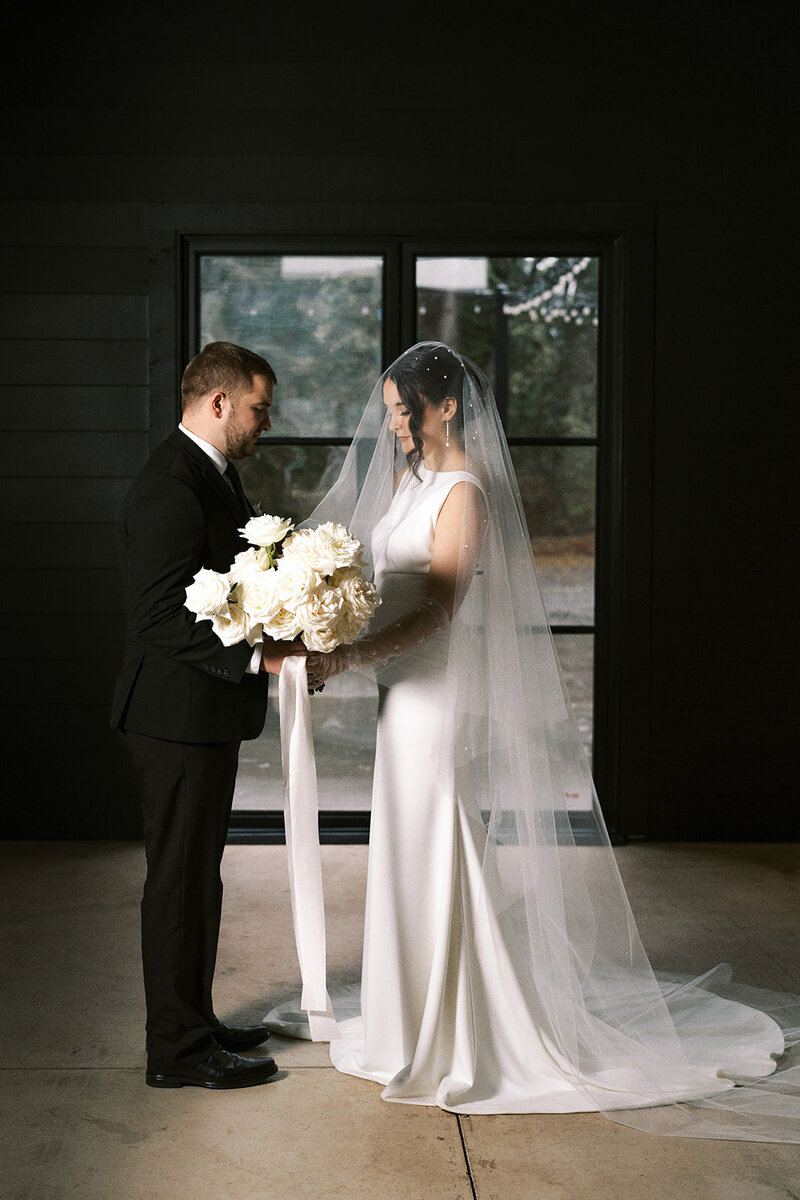 A bride and groom hold hands, representing a gallery from the wedding portfolio of Among the Oaks. 