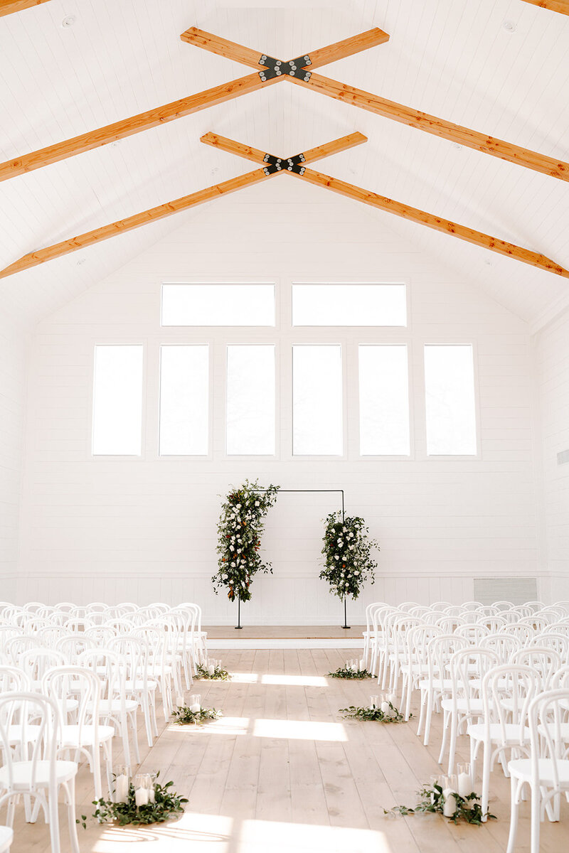 Swank Soiree Dallas Wedding Planner Haile and Christian - white barn ceremony venue with greenery and candles