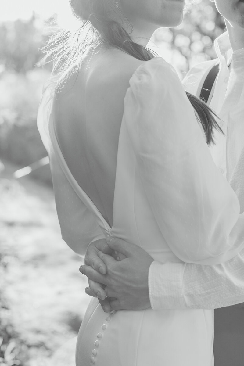 Groom holding hands on bride's back