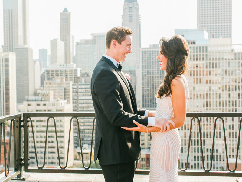 A dramatic and elegant bridal portrait on a Chicago rooftop, featuring a bride in a Naeem Khan wedding dress and fur stole with the city skyline behind her.