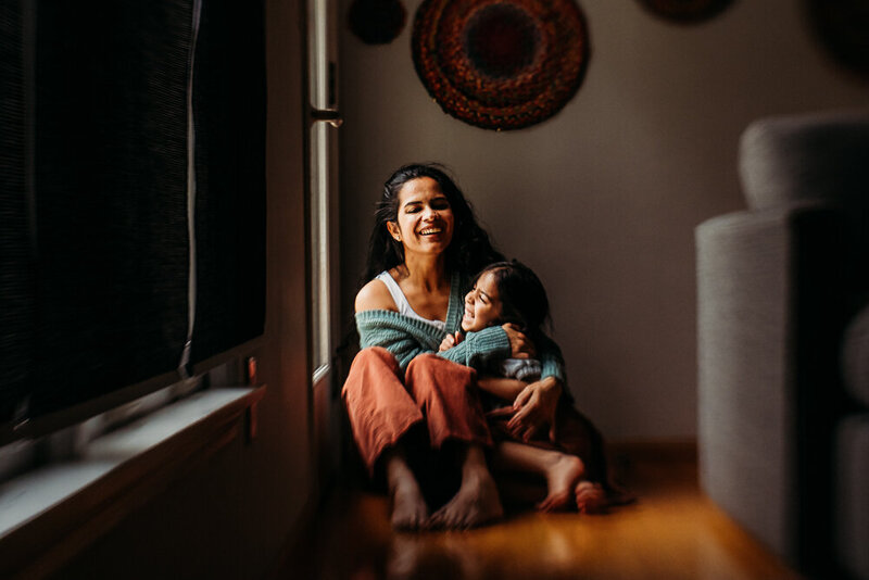 In home relaxed session with mother and daughter laughing in North east Ohio in relaxed, unposed photo session.