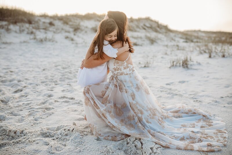 Pensacola Photographer, Jennifer Beal Photography - Photo session in Perdido Key, FL. Mother and Daughter candid photo of daughter hugging mom on the beach.