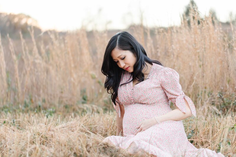 pregnant mother in tall grass at sunset