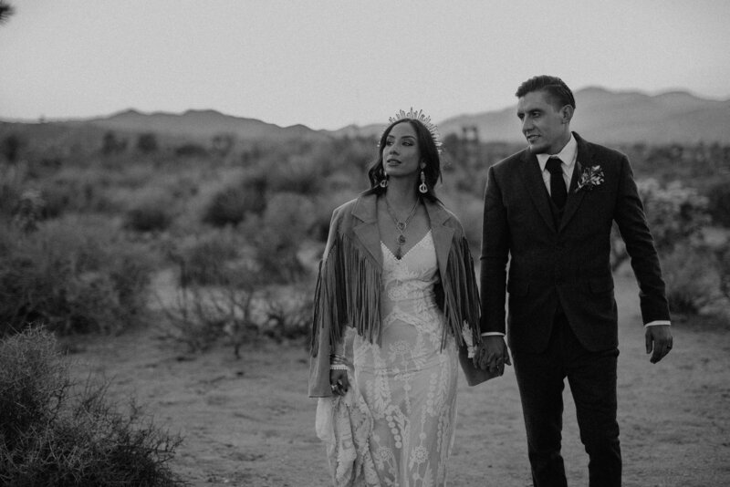 black and white image bride and groom holding hands