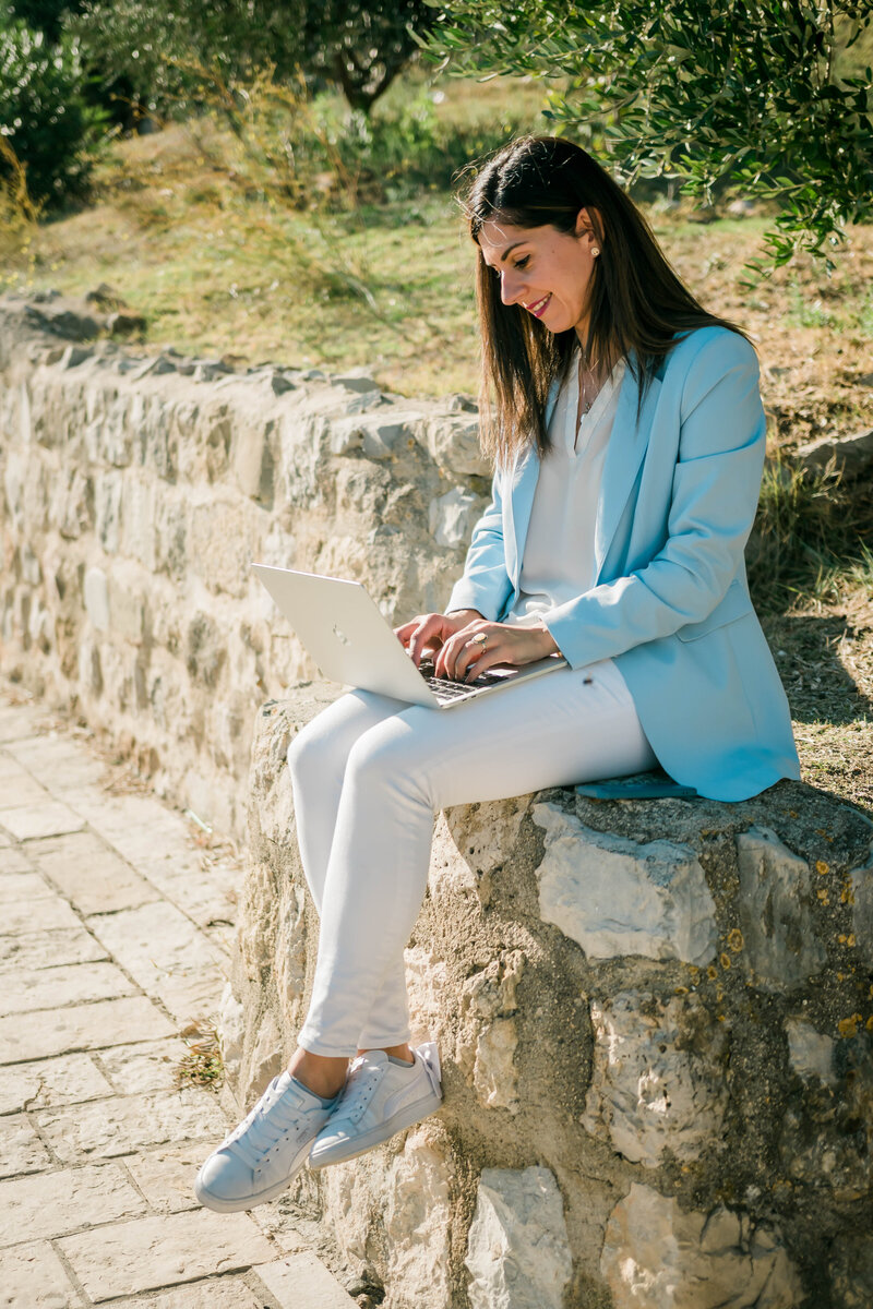 Vitual CFO services, digital nomad female entrepreneur working on her laptop in a park