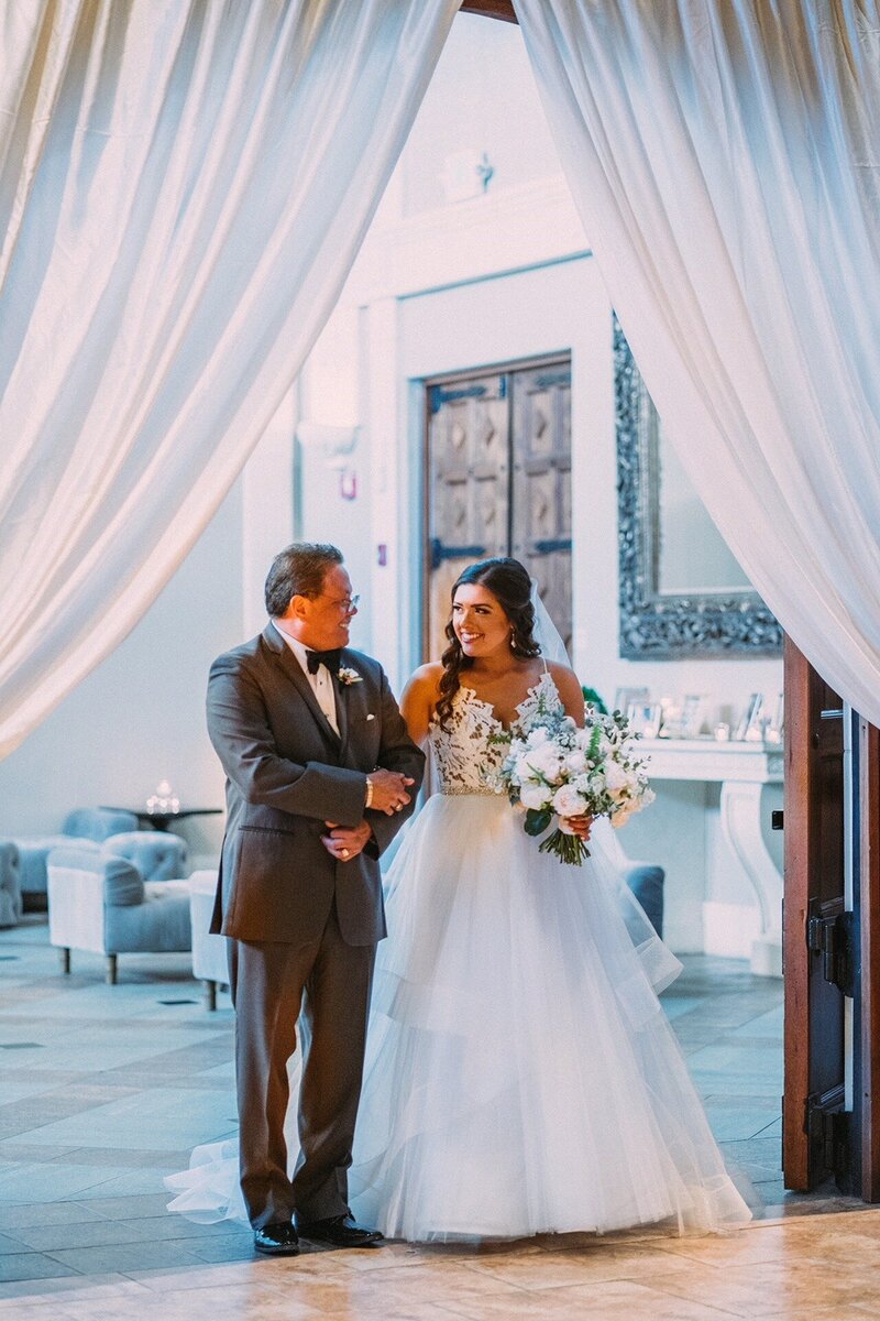 A joyful bride and groom dancing together during their reception, surrounded by friends and family.