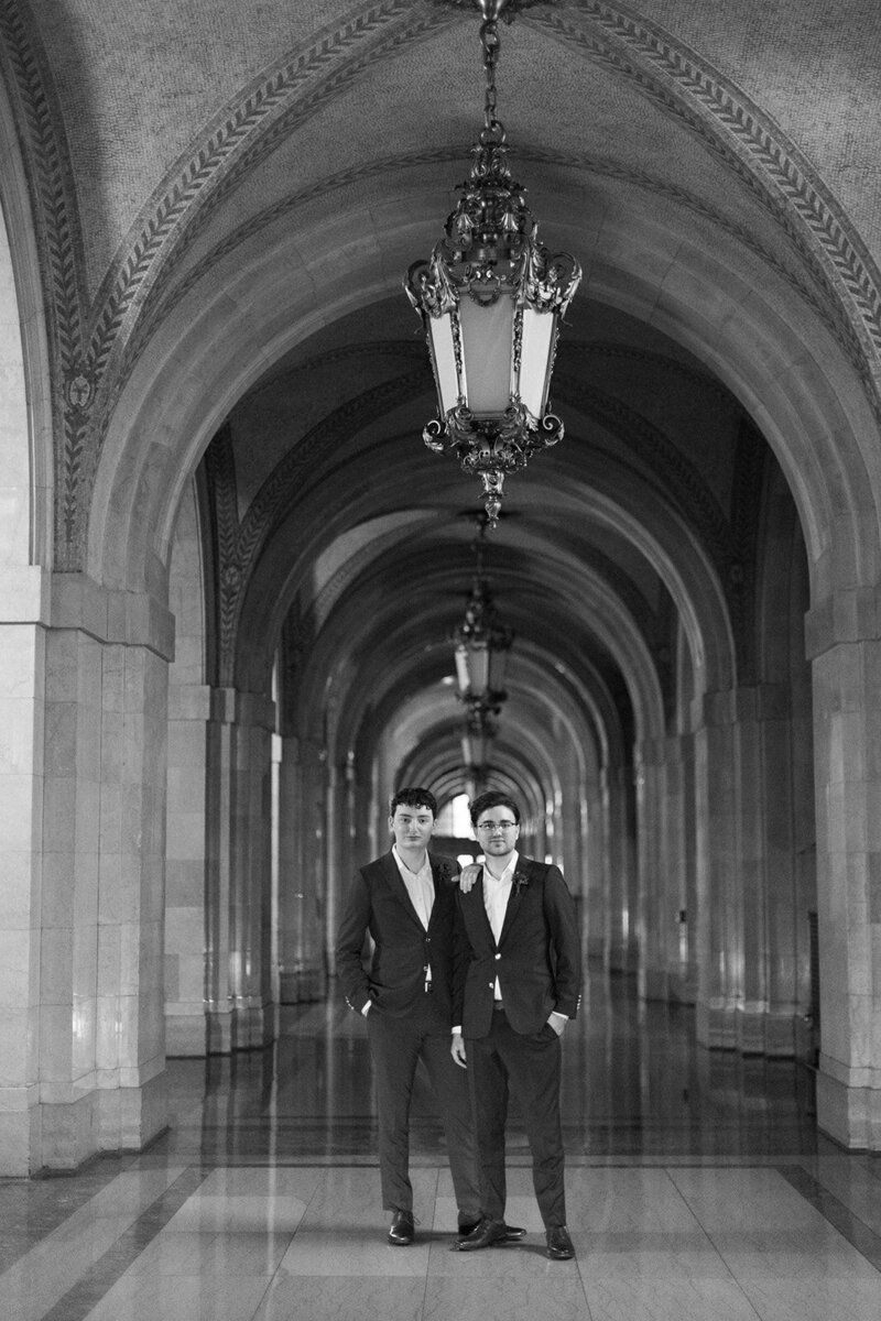 portrait of two grooms inside of city hall