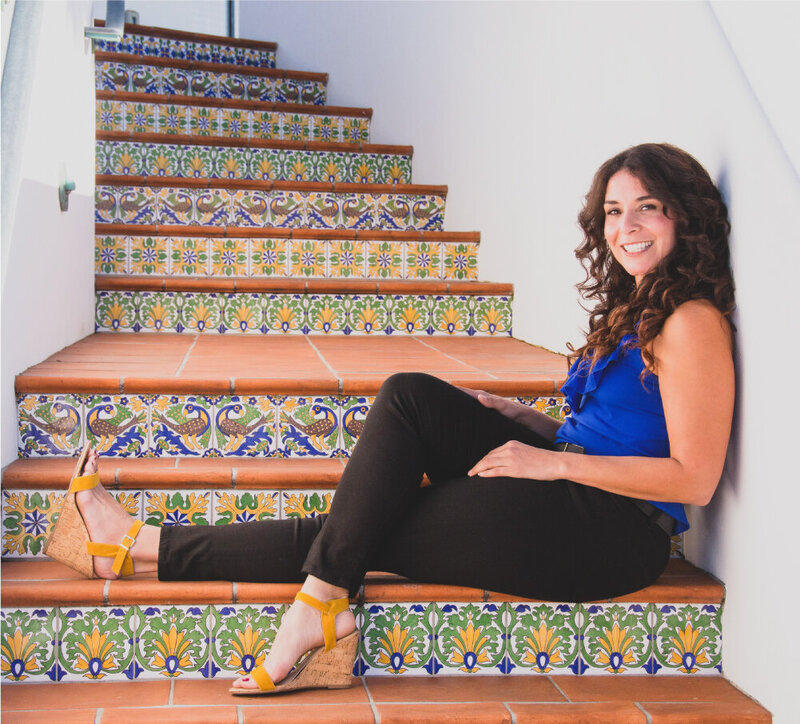 Melissa smiling and sitting colorful stairs