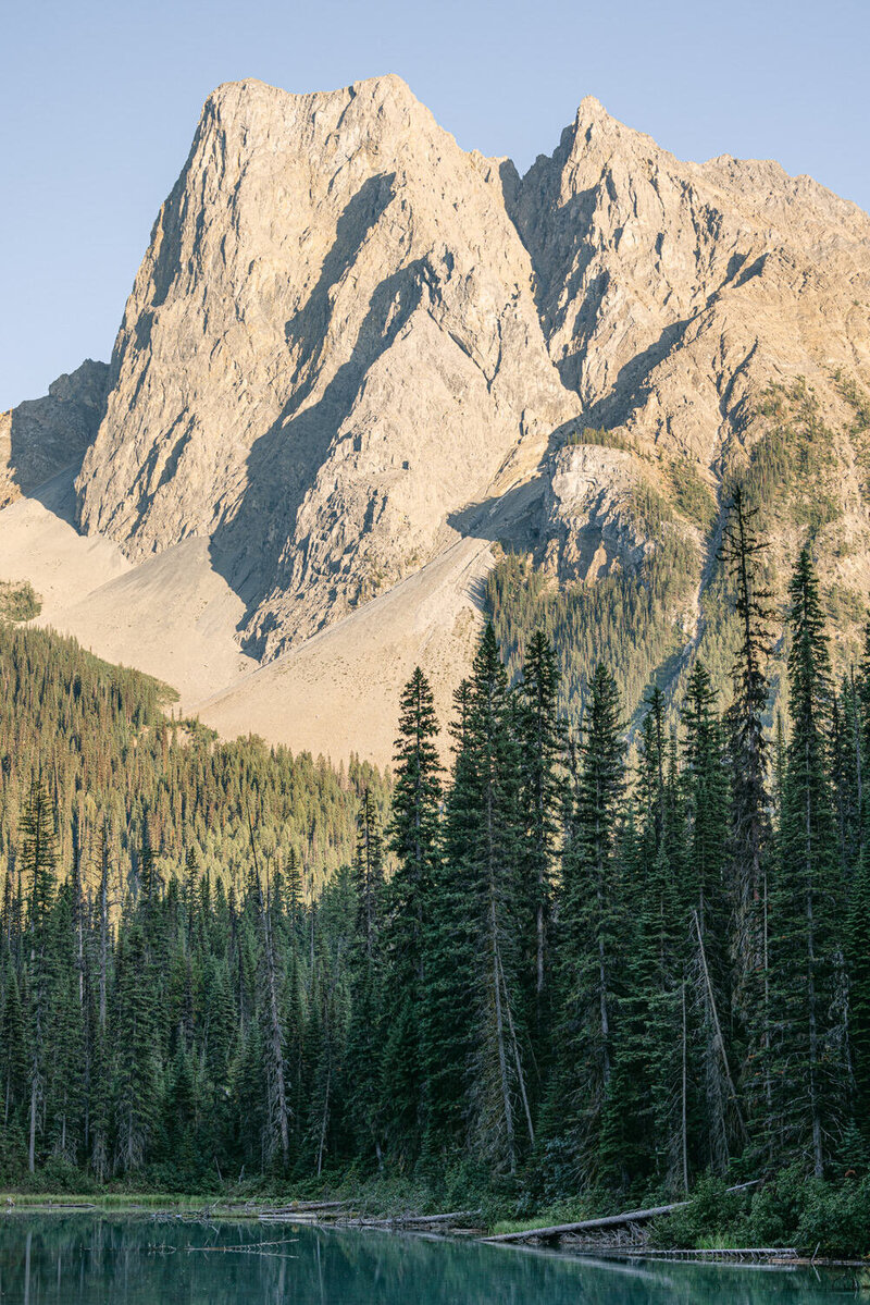 A breathtaking photograph of the mountains in Banff National Park, captured from the wooden bridge at Emerald Lake Lodge before the bride and groom entered their reception. A serene moment in a stunning natural setting.