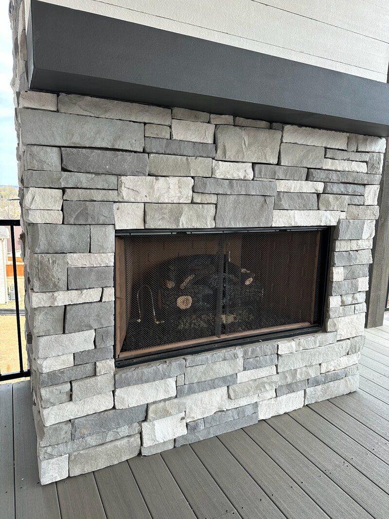 A fireplace with a marble-like tile.