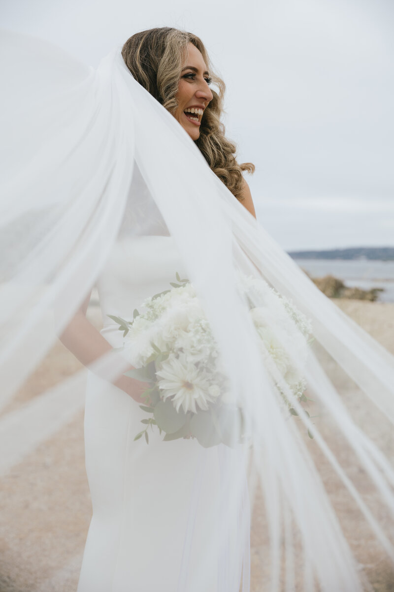 A bride on the beach with her veil
