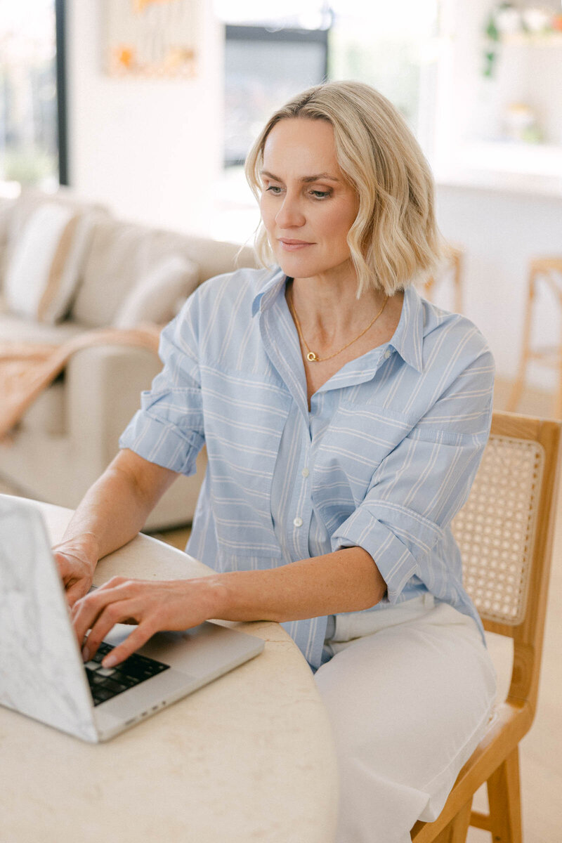 Zelda Green, relaxed and casual, sitting at her desk, working on her podcast and business resources.