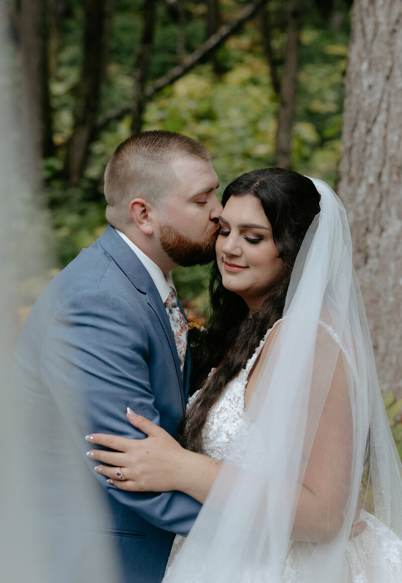 A couple standing together holding a bouquet of flowers after their wedding ceremony. 