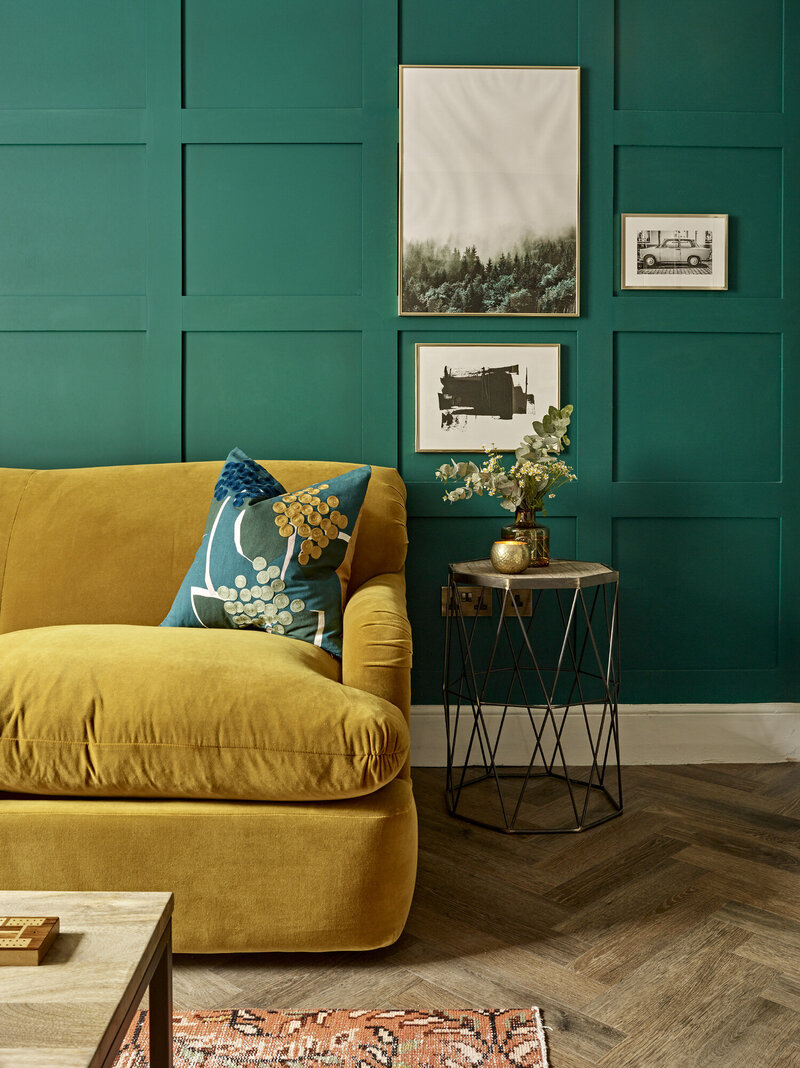 rich turquoise accent wall and mustard gold couch styled