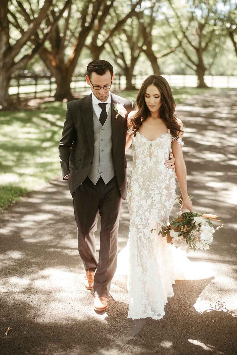 Bride & Groom Walking in Tree Lined Estate Driveway with Bouquet - Kayla & Bill | Oakshire Estate & Airfield Luxury Wedding Yakima Washington