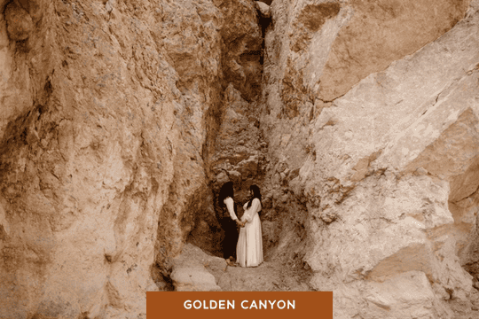 Brides standing in a narrow rock formation as they face one another