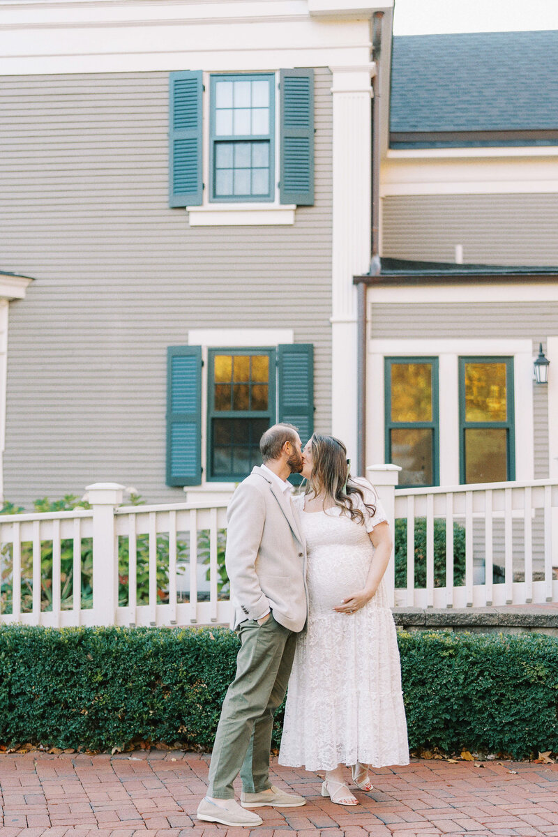 a man kissing his pregnant wife on the head