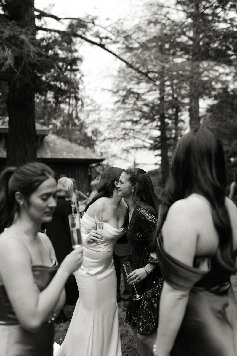 Candid cocktail hour moment between the bride and her mom captured by Emmie Verdell Photo.