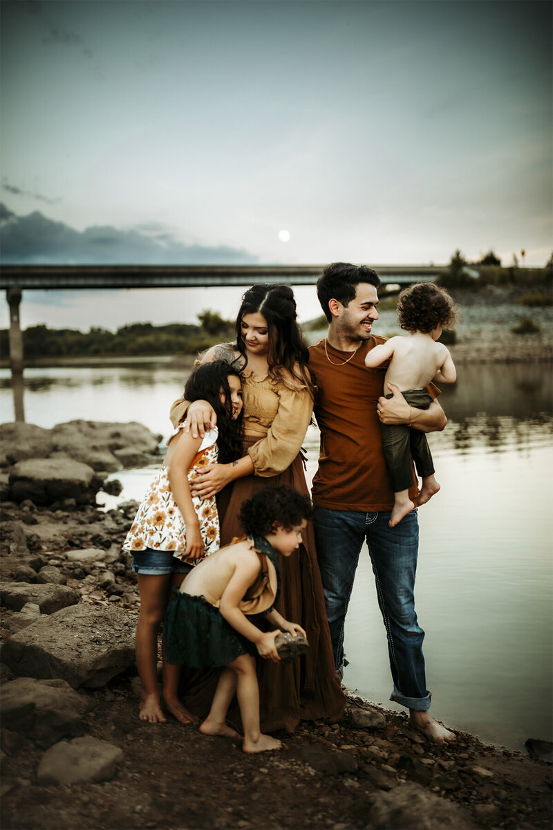 family plays at the lake during photo session