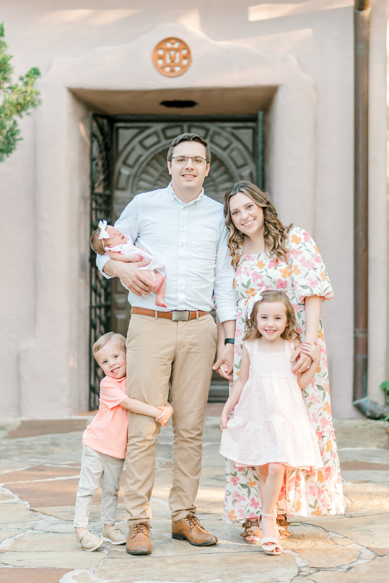 top san antonio wedding photographer Sarah Thompson standing with her family smiling.