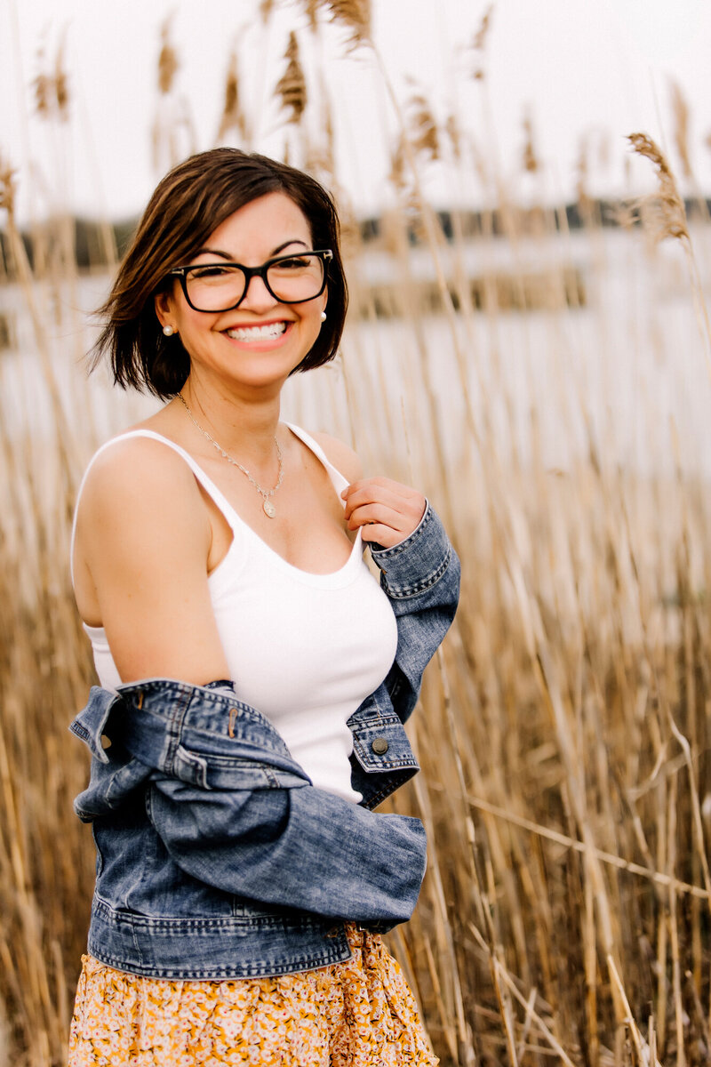 Women sitting on a couch holding a cup of coffee & smiling for her dating profile photo