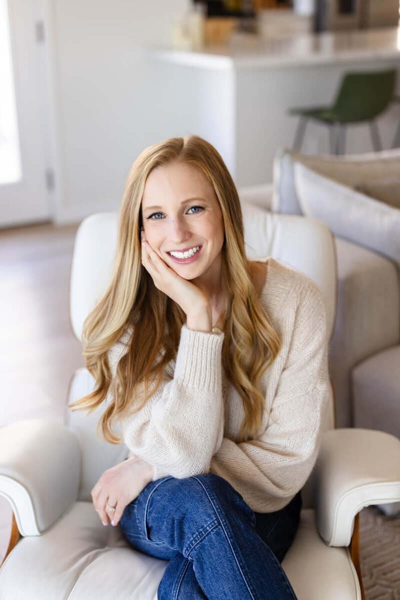 Mary Pernicano, San Diego realtor, smiling while seated in a bright modern living room, representing her friendly and strategic approach to real estate — Mary Pernicano Real Estate.