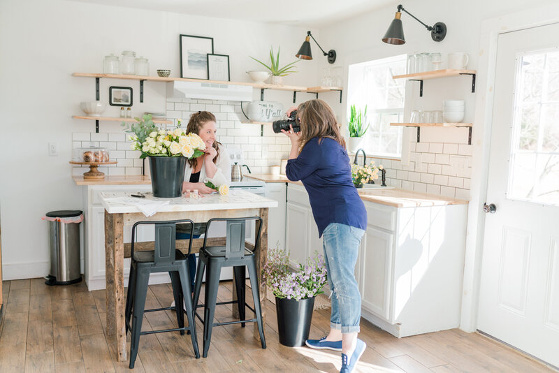 Behind the scenes image of brand photographer Amanda Richardson photographing a client, the owner of a boutique florist