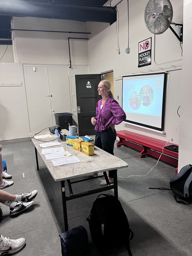 Morgan Walker Sports nutrition consultant leading a team talk for athletes about performance fueling, recovery, and hydration strategies to improve energy and endurance.