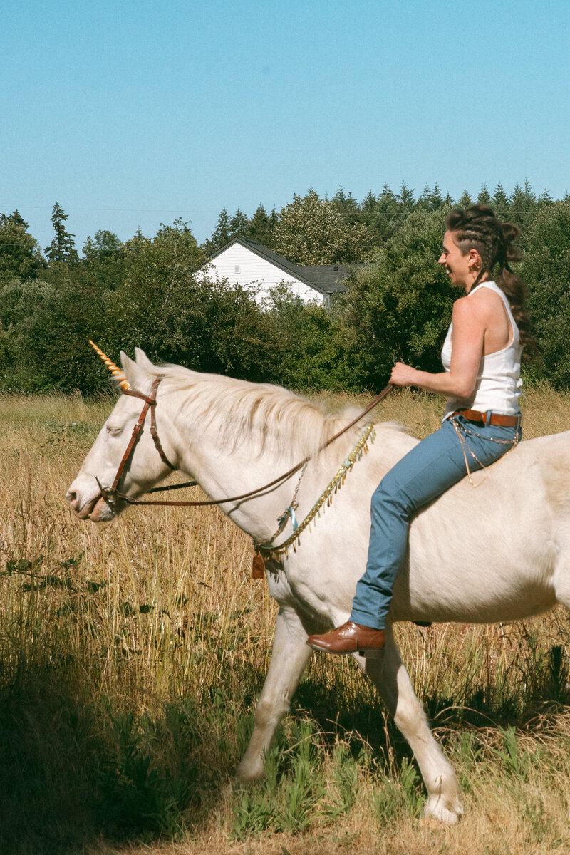 Bride riding a white horse to the alter.