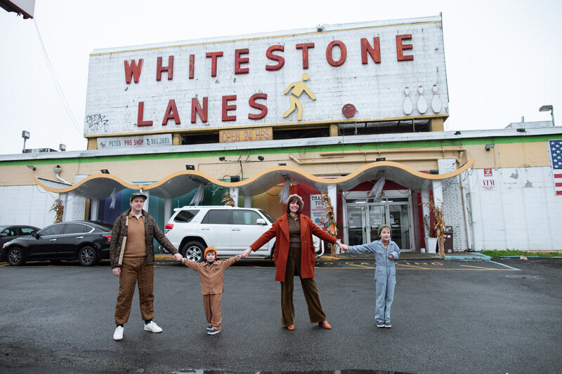 nyc family portrait with two kids wearing vintage clothes outside whitestone lanes bowling alley