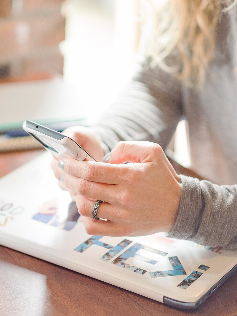 Woman scrolling through phone looking for photos