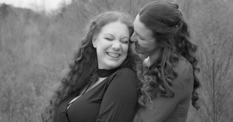 lesbian brides smile and laugh as they whisper things to each other