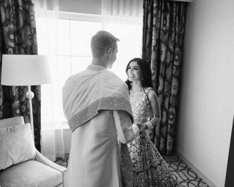 A bride and groom laugh as they exit their wedding ceremony