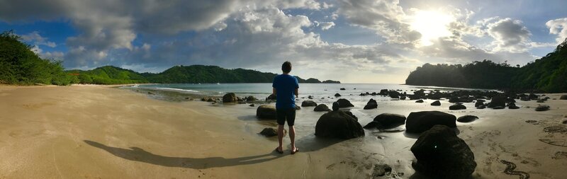 Brian Johnson, owner of With This Ring Wedding Films + Photo, filming a bride and groom during a destination wedding in Mexico under palm trees on a sunny beach