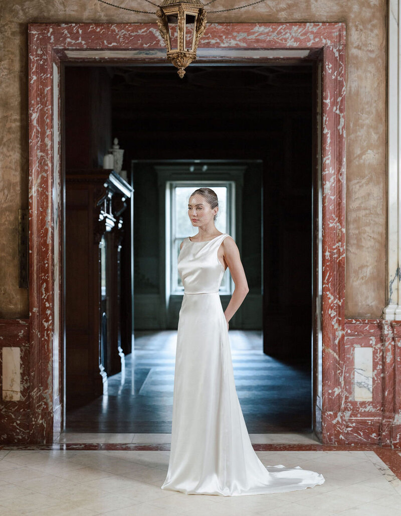 bride wearing silk wedding dress in mansion